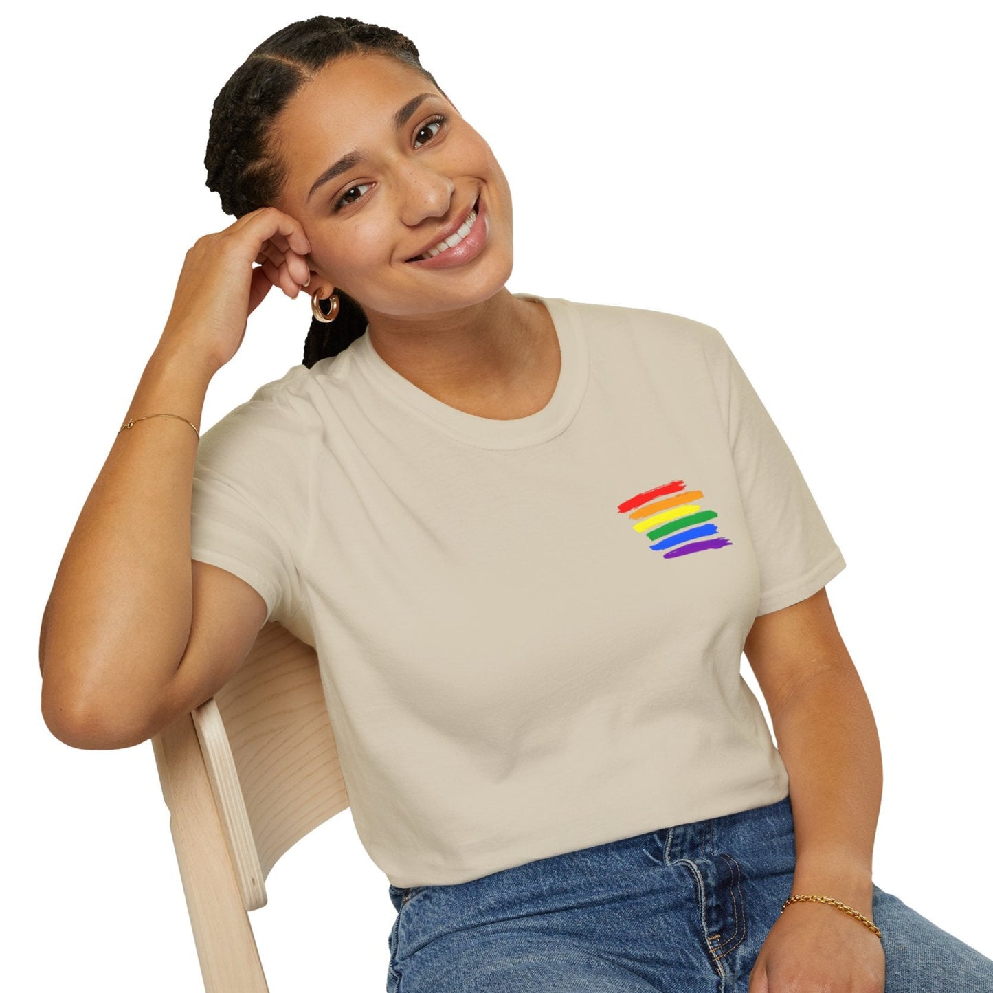 Woman smiling while wearing a True Colours Rising rainbow pride t-shirt with colorful stripes.