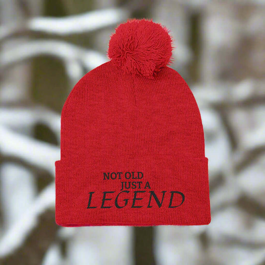 Not Old Just a Legend Pom-Pom Winter Beanie displaying a red knit design with a pom pom on top.