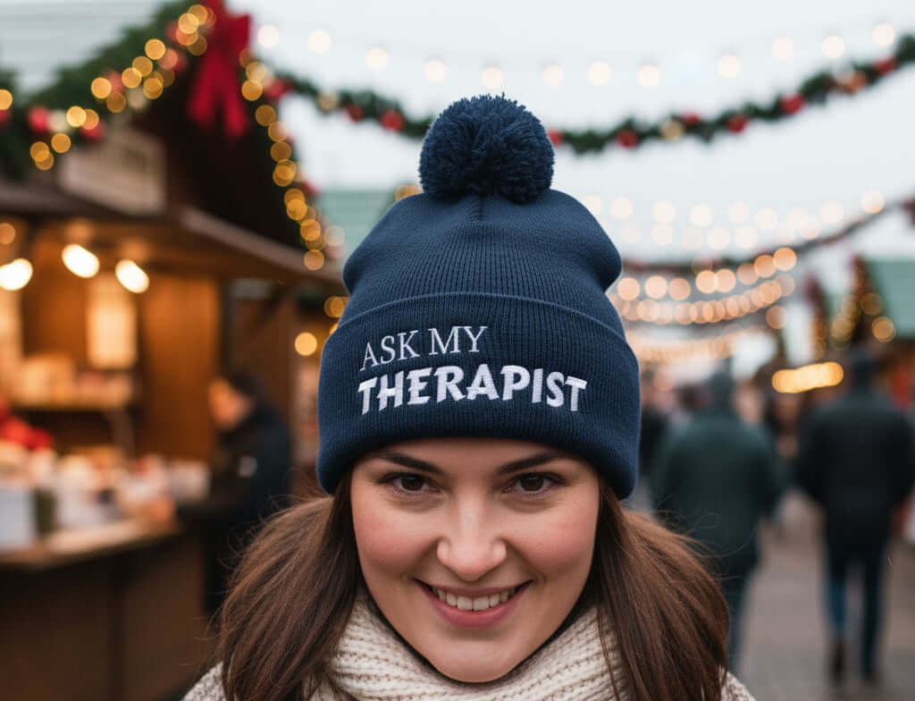 Navy blue beanie with pom-pom and 'Ask My Therapist' text on a white background