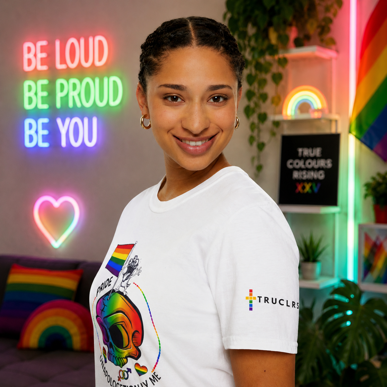 Plus-size woman wearing the Unapologetically Me pride T-shirt with bold rainbow graphics and TRUE COLOURS RISING branding.