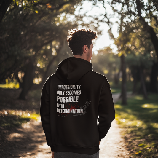 Black hoodie
with motivational quote about determination worn outdoors on a forest path