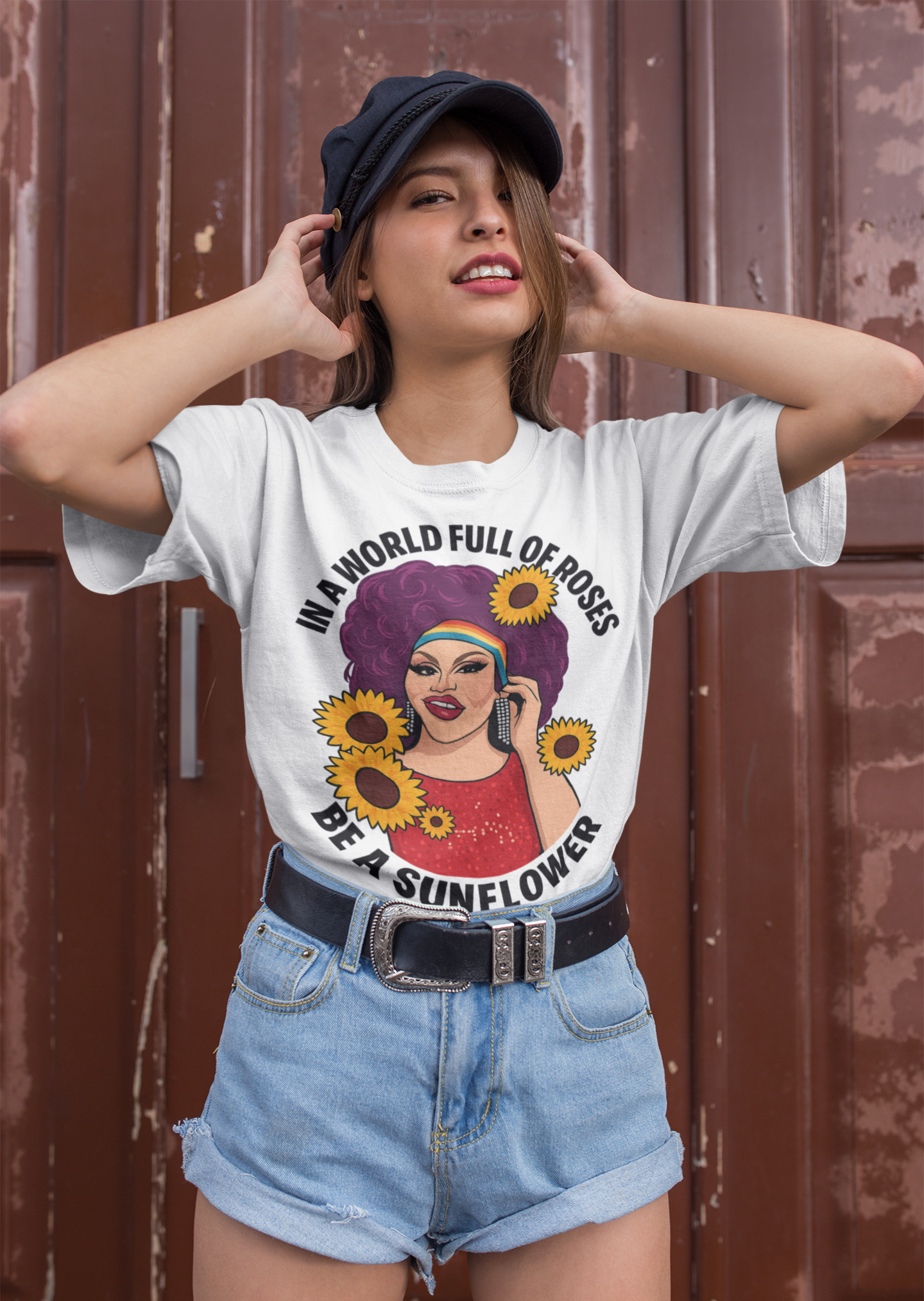 White crewneck graphic shirt featuring queer drag illustration with bold purple hair and sunflowers.