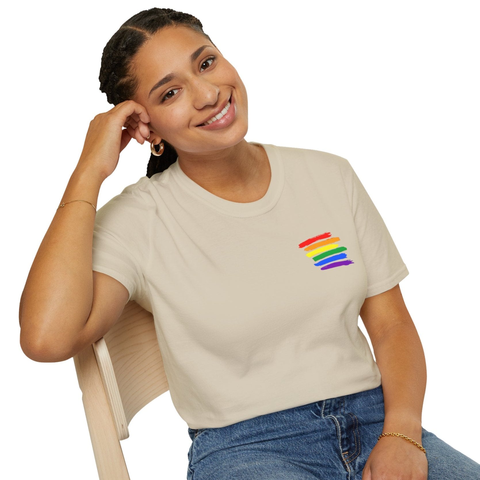 Woman smiling while wearing a True Colours Rising rainbow pride t-shirt with colorful stripes.
