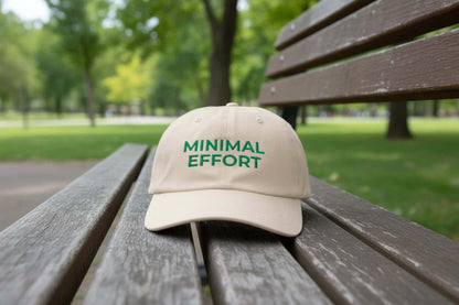 Close-up of  a neutral beige unstructured dad cap with Minimal Effort embroidery