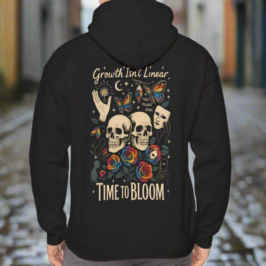 Back view of the black hoodie featuring bold graphics, skulls, flowers, and the text 'Growth Isn't Linear - Time to Bloom'.