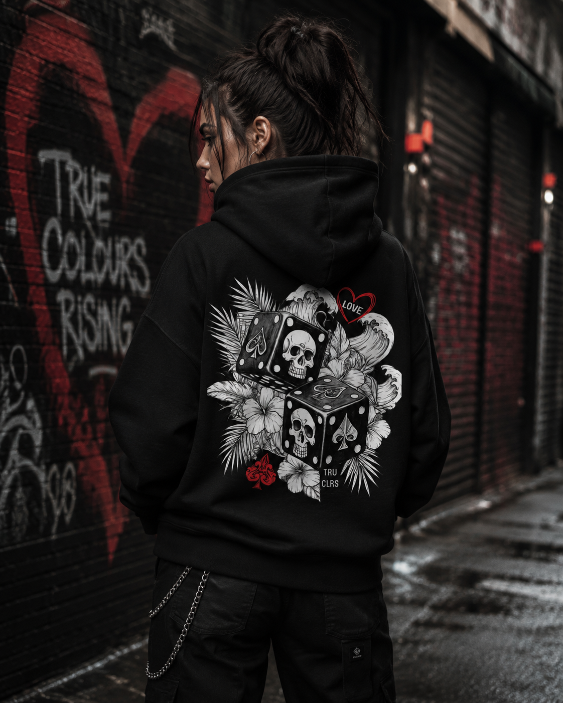 Love Is a Gamble premium black hoodie styled in an urban London setting with red buses and city streets.