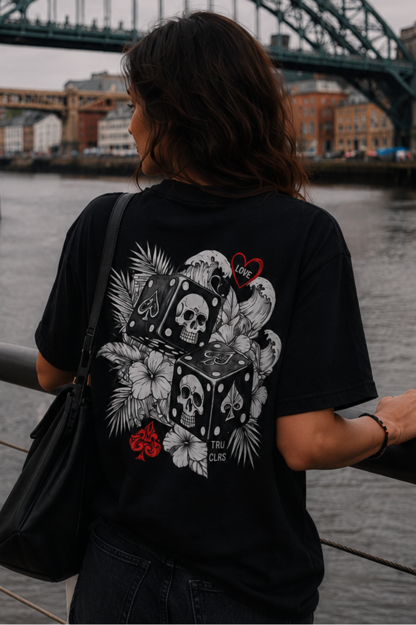 Alternative streetwear model wearing black graphic tee beside Newcastle Tyne Bridge