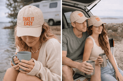 Man and woman wearing matching Take It Easy dad caps sitting by the coast