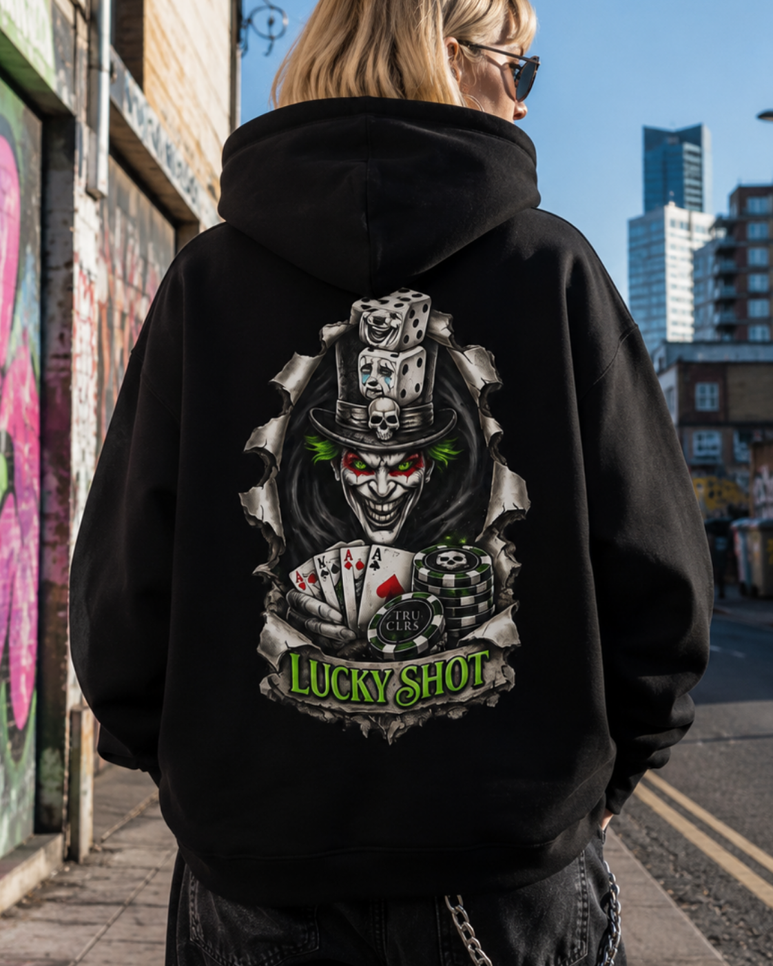 Woman wearing the Lucky Shot black hoodie with Joker poker graphic back print in an urban UK street.