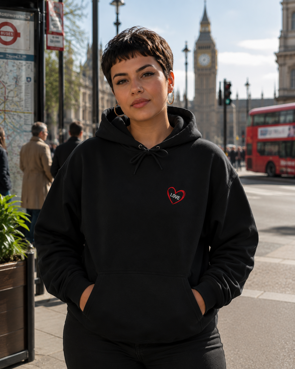 Woman with short cropped hair wearing the Love Is a Gamble hoodie featuring skull dice artwork in central London.