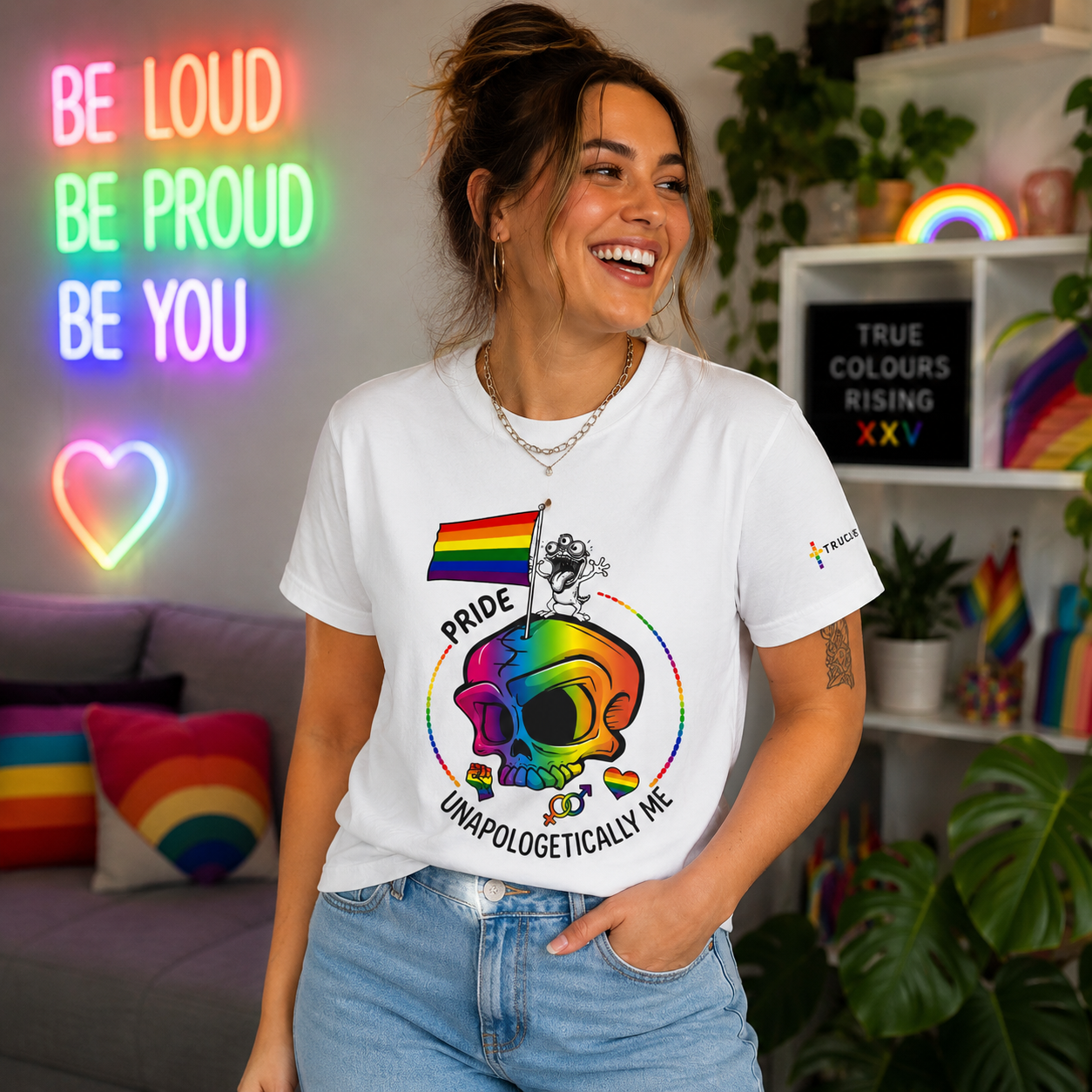 Woman wearing the Unapologetically Me pride T-shirt with colourful rainbow skull artwork and TRUE COLOURS RISING sleeve branding.