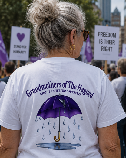 Person wearing a white t-shirt with 'Grandmothers of the Hagued' design and text at a protest event.