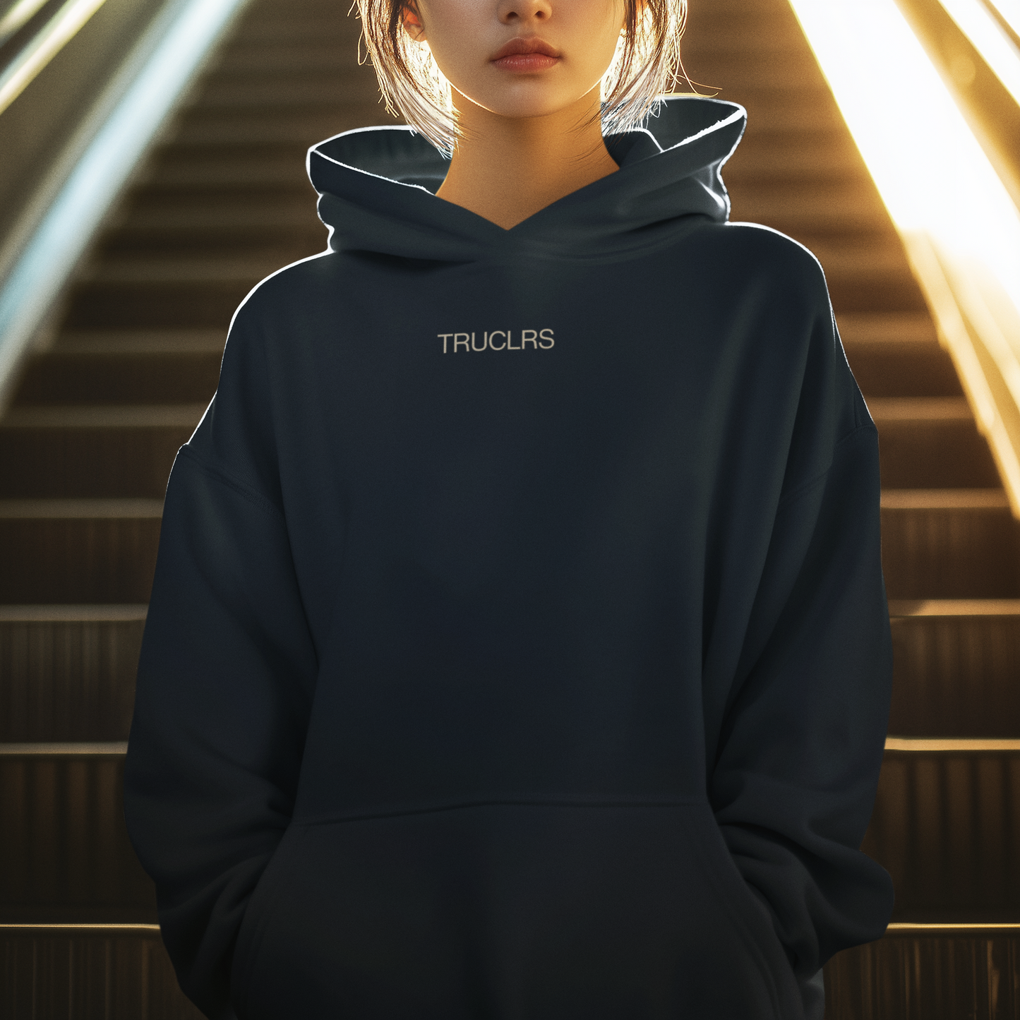 Person wearing a dark hoodie with 'TRUCLRS' branding in an indoor setting.