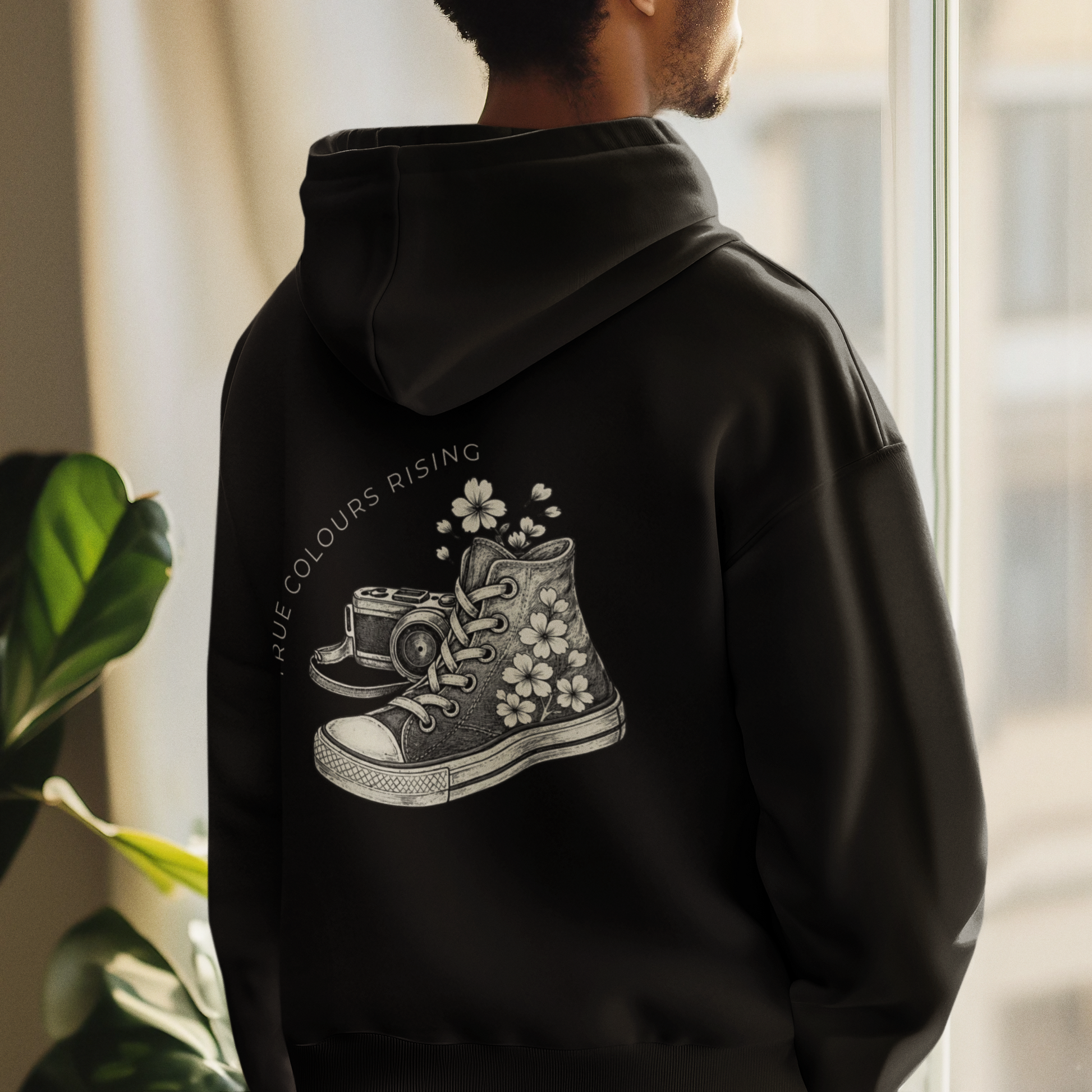 Creative fashion hoodie with black line art sneaker camera and floral details
