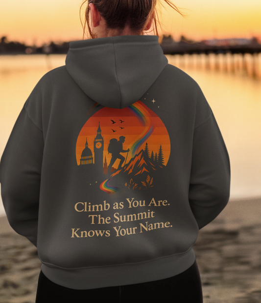 Black hoodie with hiker silhouette climbing rainbow trail at sunset and quote ‘Climb as You Are. The Summit Knows Your Name.’