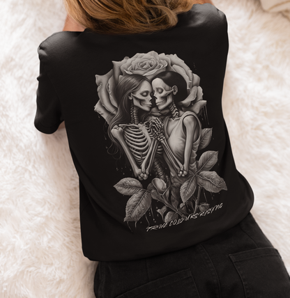 Back view of black T-shirt featuring two skeletons holding hands framed by a rose

Close-up of skeleton couple tattoo-style artwork on True Love Never Dies tee
