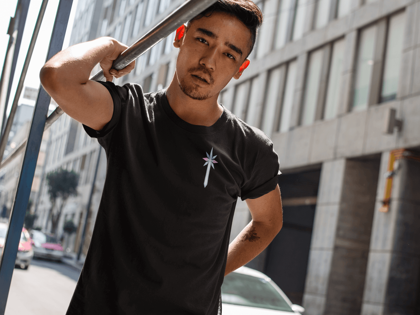 Minimal black tee showing a small vertical trans pride symbol