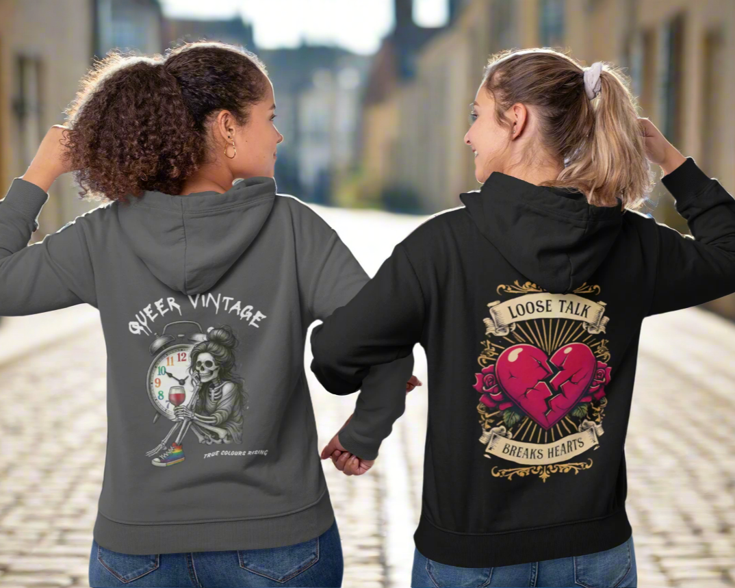 two women wearing a black hoodie and grey hoodie. One that has queer vintage and the other says loose talk breaks hearts. Winter Warmers