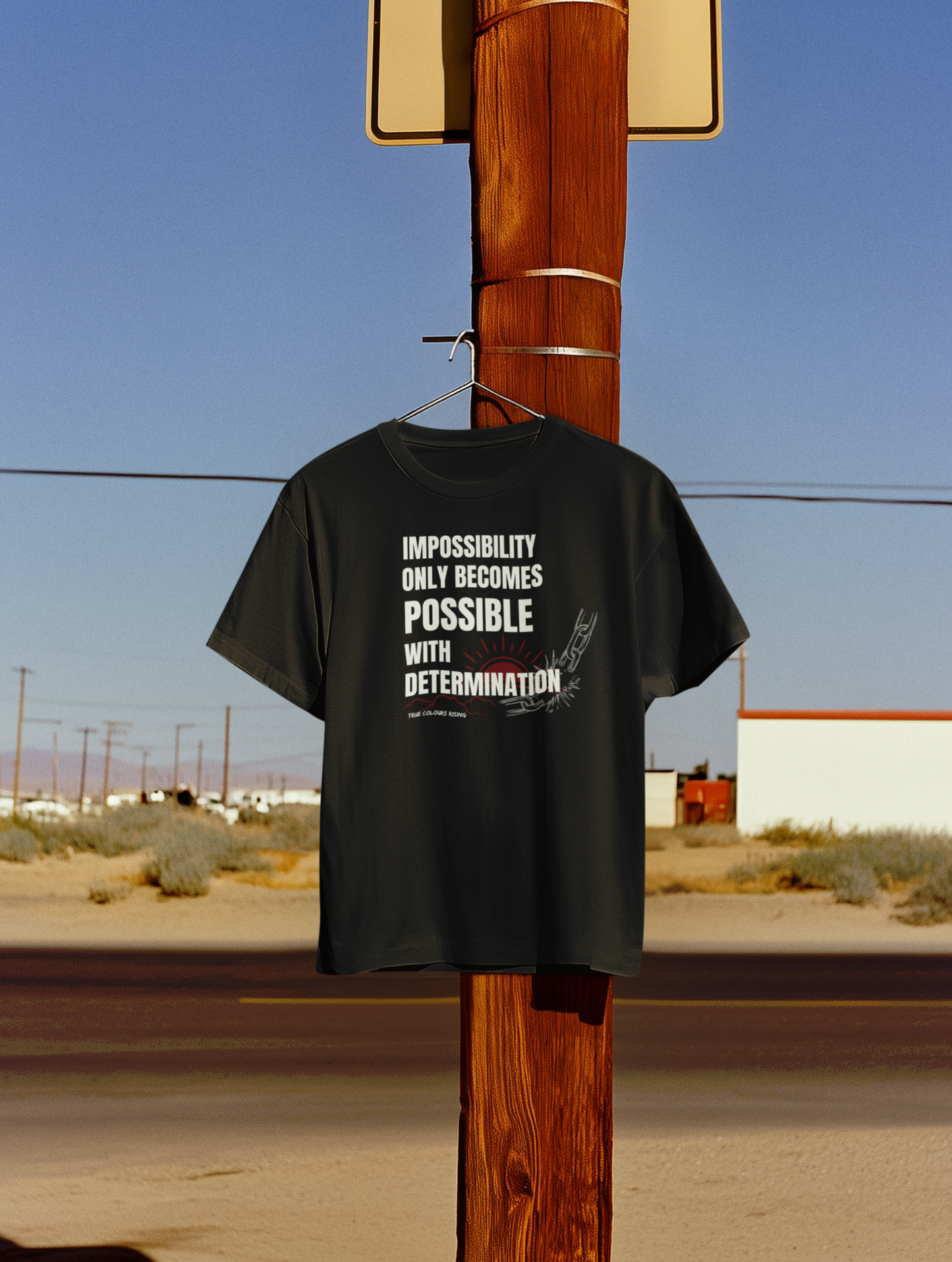 Black T shirt featuring a bold motivational quote “Impossibility Only Becomes Possible With Determination” with a rising sun and broken chain graphic