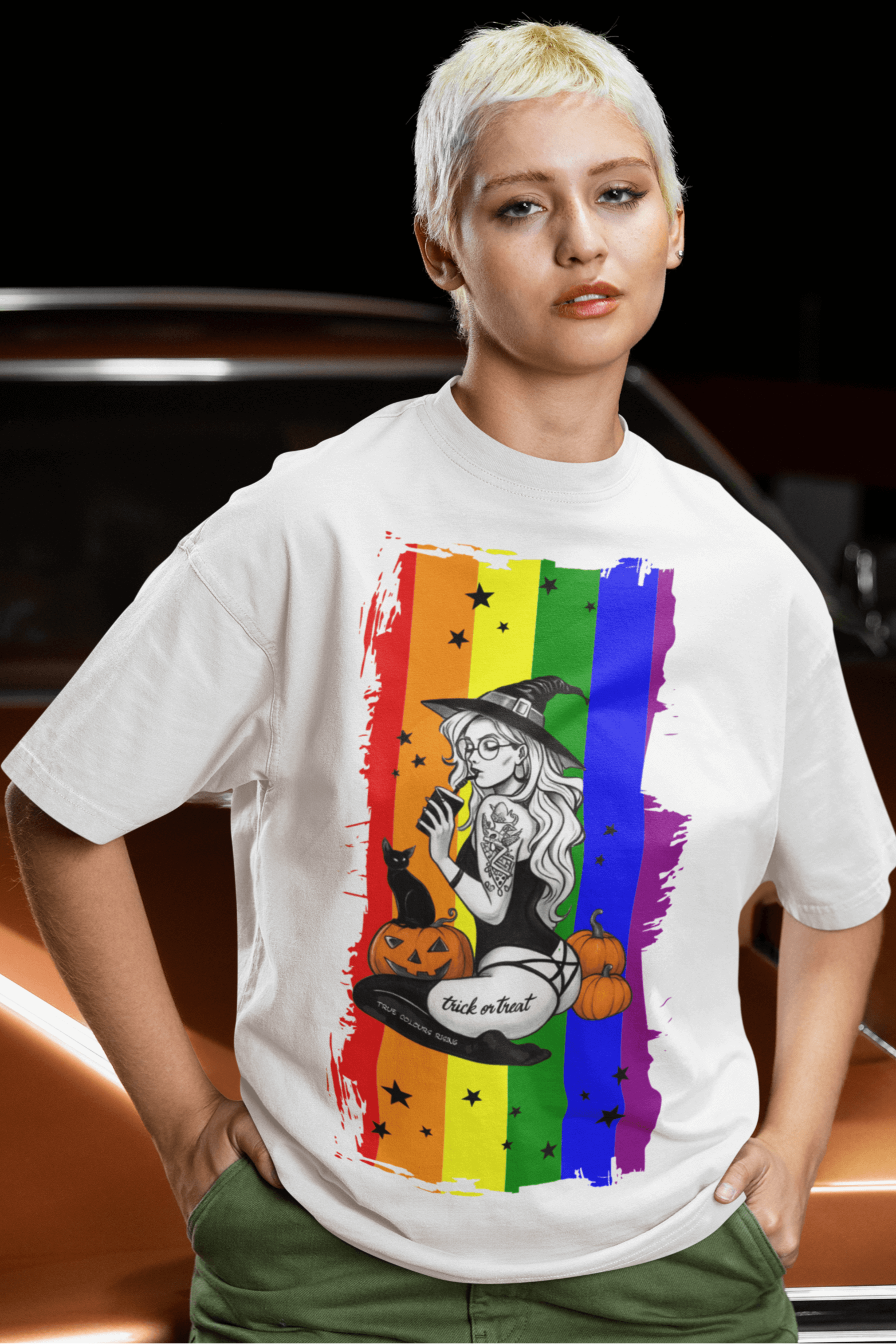 Witchy Pride Halloween T-shirt on model, featuring vibrant rainbow background, pumpkins, and a playful witch design.